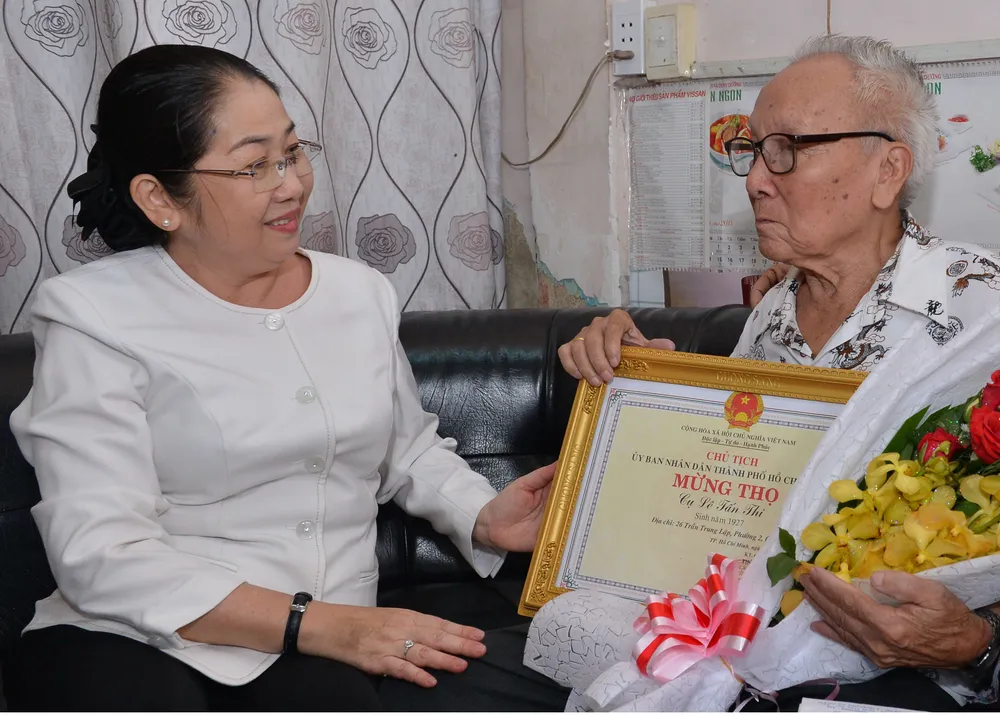Phó Bí thư Thành ủy TPHCM Võ Thị Dung chúc mừng cụ Lê Tấn Thi, 91 tuổi, cán bộ hưu trí, ngụ phường 2 (quận 6). Ảnh: Việt Dũng