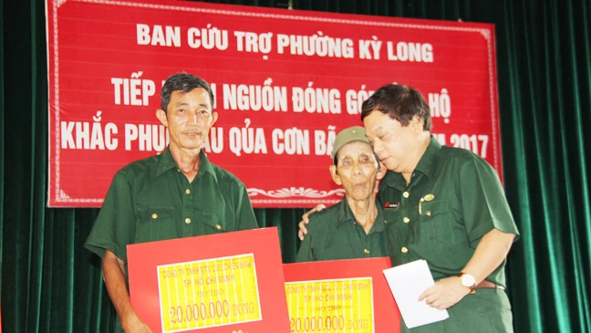 Đại diện lãnh đạo Công ty TNHH MTV Cựu chiến binh trao tiền hỗ trợ các cựu chiến binh xây dựng lại nhà bị sập trong cơn bão số 10