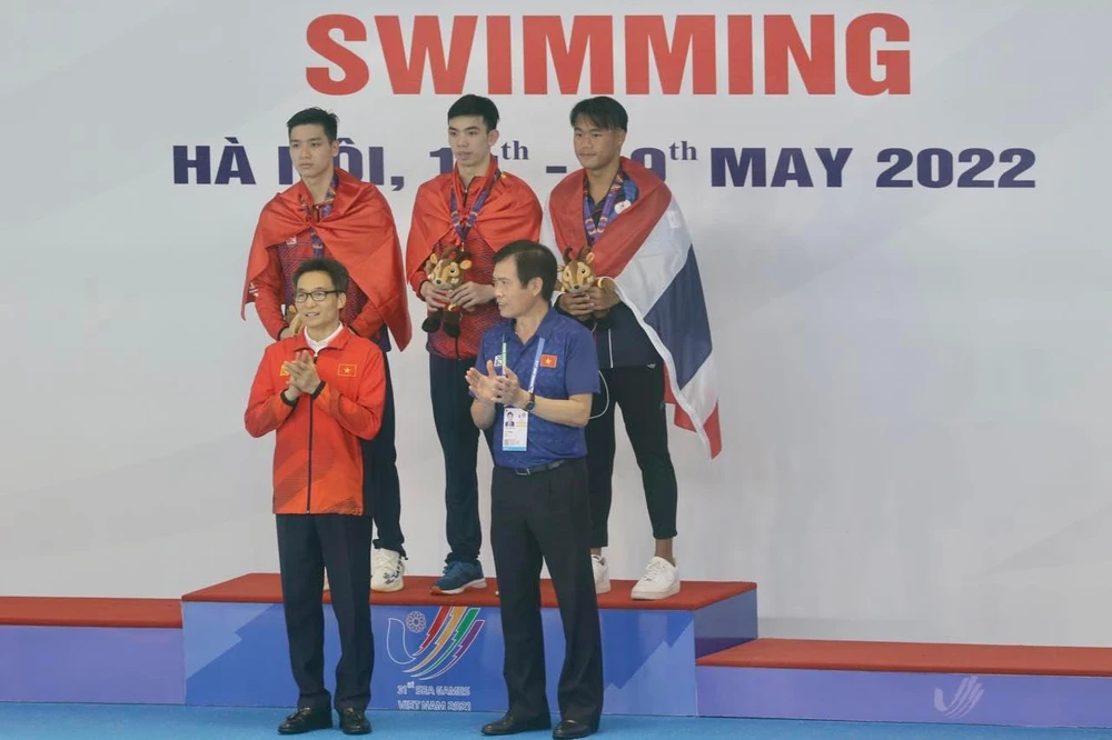 Phó Thủ tướng Chính phủ, Trưởng ban chỉ đạo quốc gia SEA Games 31 Vũ Đức Đam trao huy chương ở nội dung 1.500m. Ảnh: DƯ HẢI