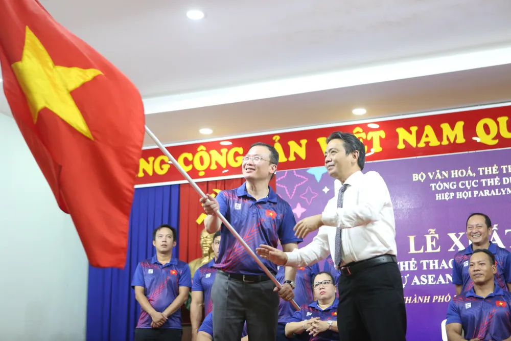 Thứ trưởng Hoàng Đạo Cương trao cờ cho Trưởng đoàn thể thao NKT Việt Nam Nguyễn Hồng Minh. Ảnh: THANH TÙNG