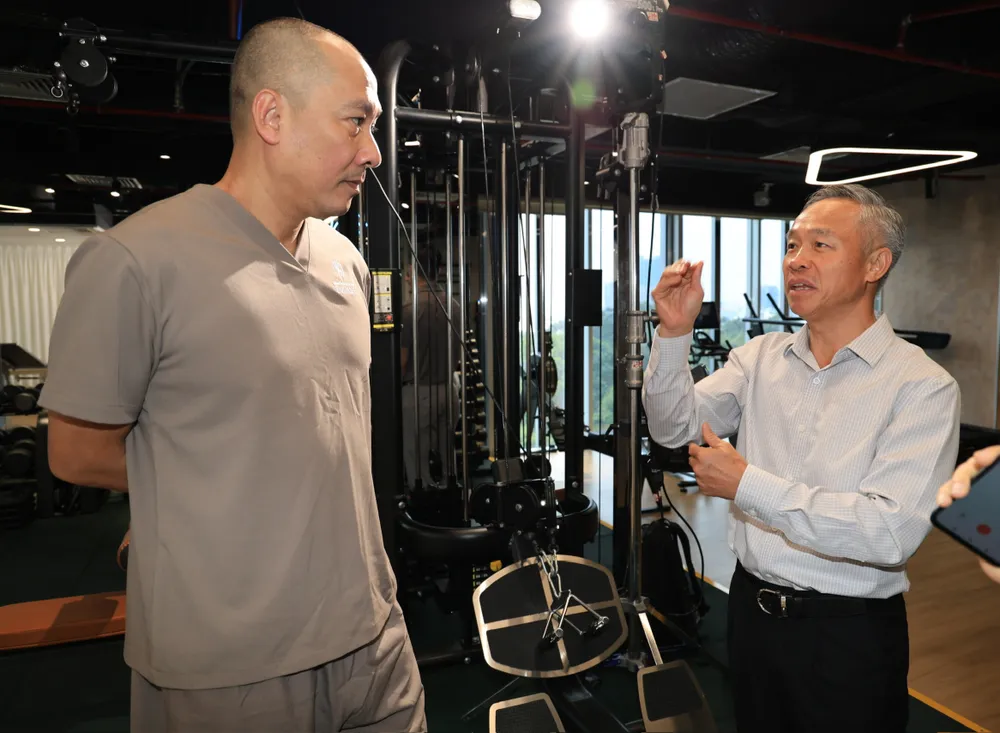 Ông Dương Công Thuyên (phải) giới thiệu về các phương pháp trị liệu với HLV Nguyễn Tuấn Kiệt. Ảnh: DŨNG PHƯƠNG 1000022833.jpg