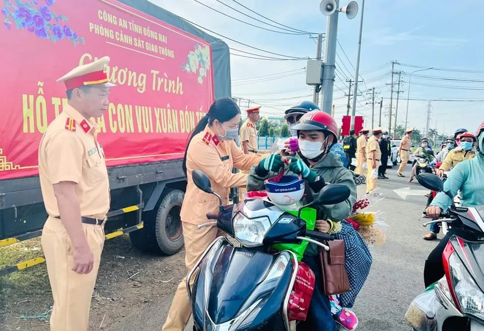 Lực lượng cảnh sát giao thông cấp mũ bảo hiểm cho người dân về tết qua địa bàn tỉnh Đồng Nai