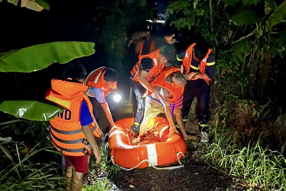 Lực lượng chức năng đưa 2 ông cháu ra khỏi vùng ngập lụt