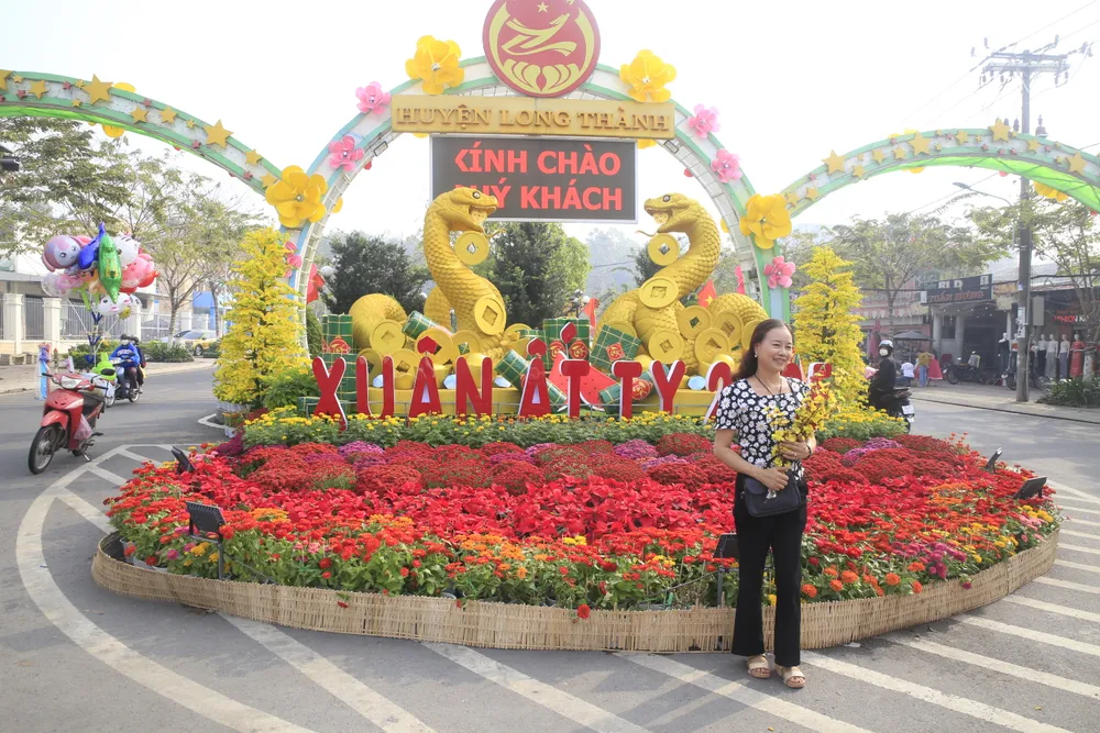 Người dân huyện Long Thành chụp ảnh trước đường hoa Tết Ất Tỵ 2025.JPG