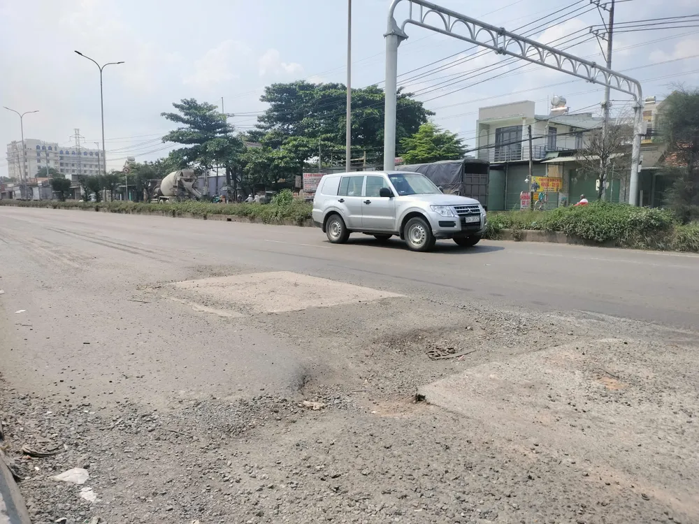 Auta se musí vyhýbat výmolům v obci Long Hung v provincii Dong Nai. 1- Xe ô tô phải né ổ gà đoạn qua xã Long Hưng, tỉnh Đồng Nai. Ảnh HOÀNG BẮC.jpg