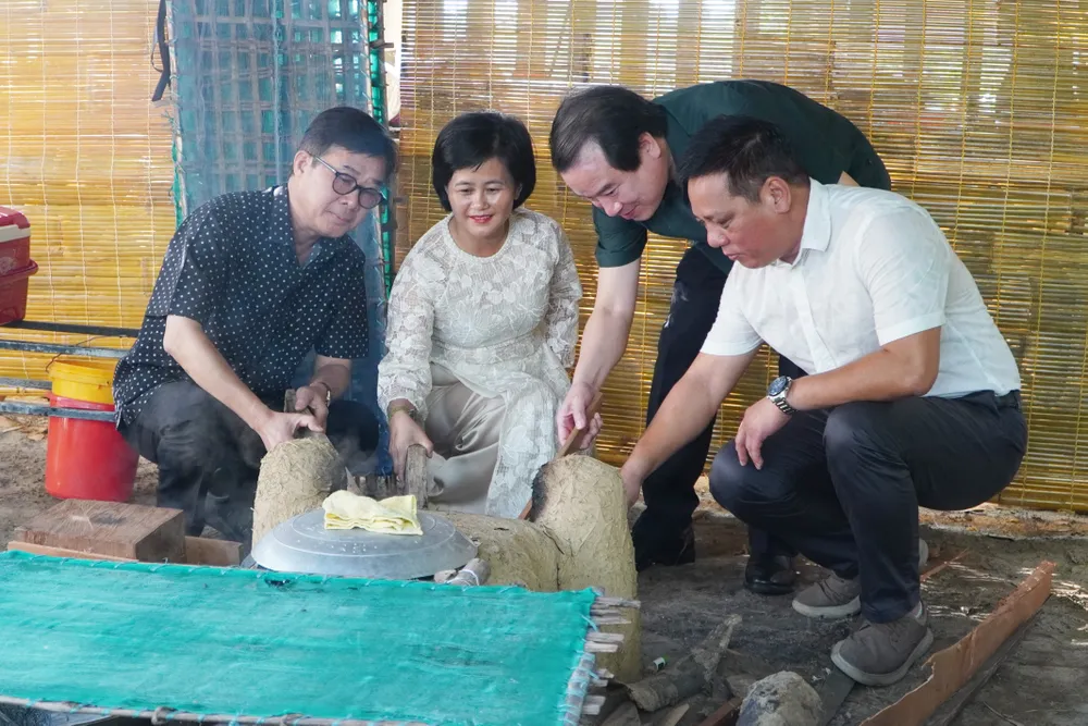 Đại biểu lãnh đạo thực hiện nghi thức nhóm lửa lò mỳ. 2.jpg