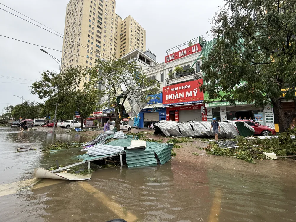 Nhiều mái tôn, bảng hiệu tại trung tâm tỉnh Nghệ An bị bão số 5 xé toạc, văng ra ngoài đường 26-8-nguoi-nghe-an-tat-bat-don-dep (23).JPG