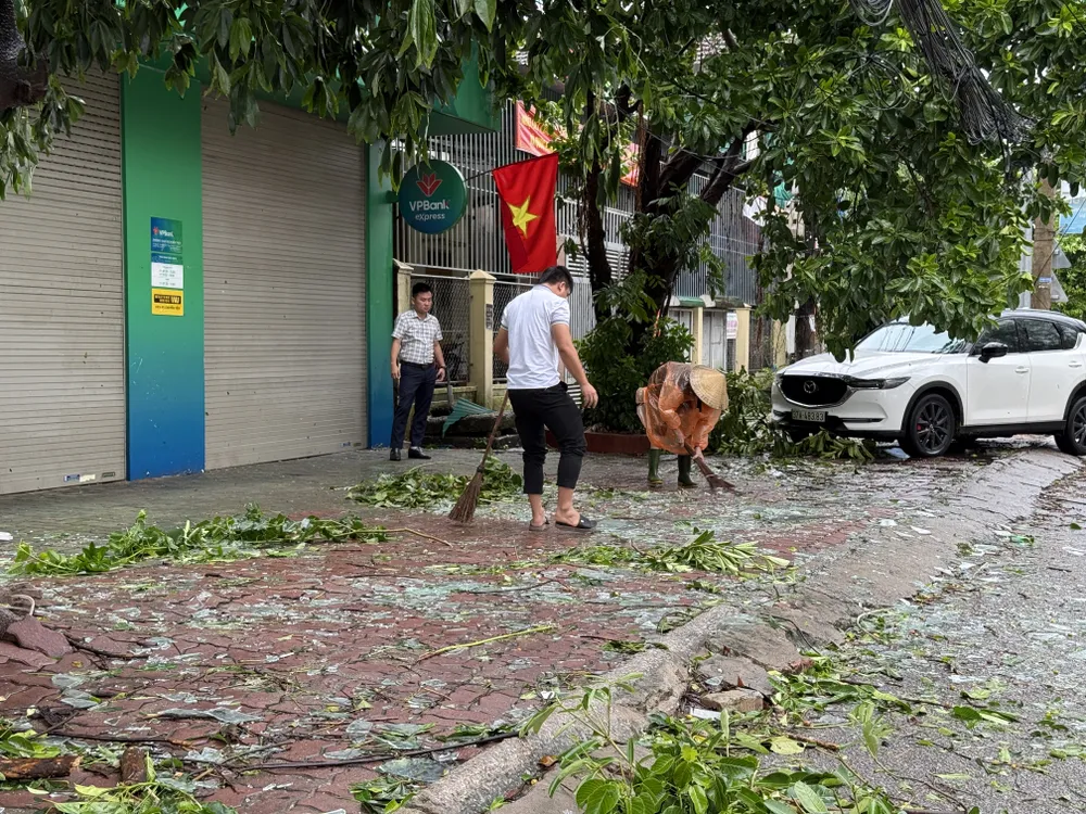 Dọn mảnh kính cửa hàng bị vỡ do bão số 5 gây ra 26-8-nguoi-nghe-an-tat-bat-don-dep (4).JPG