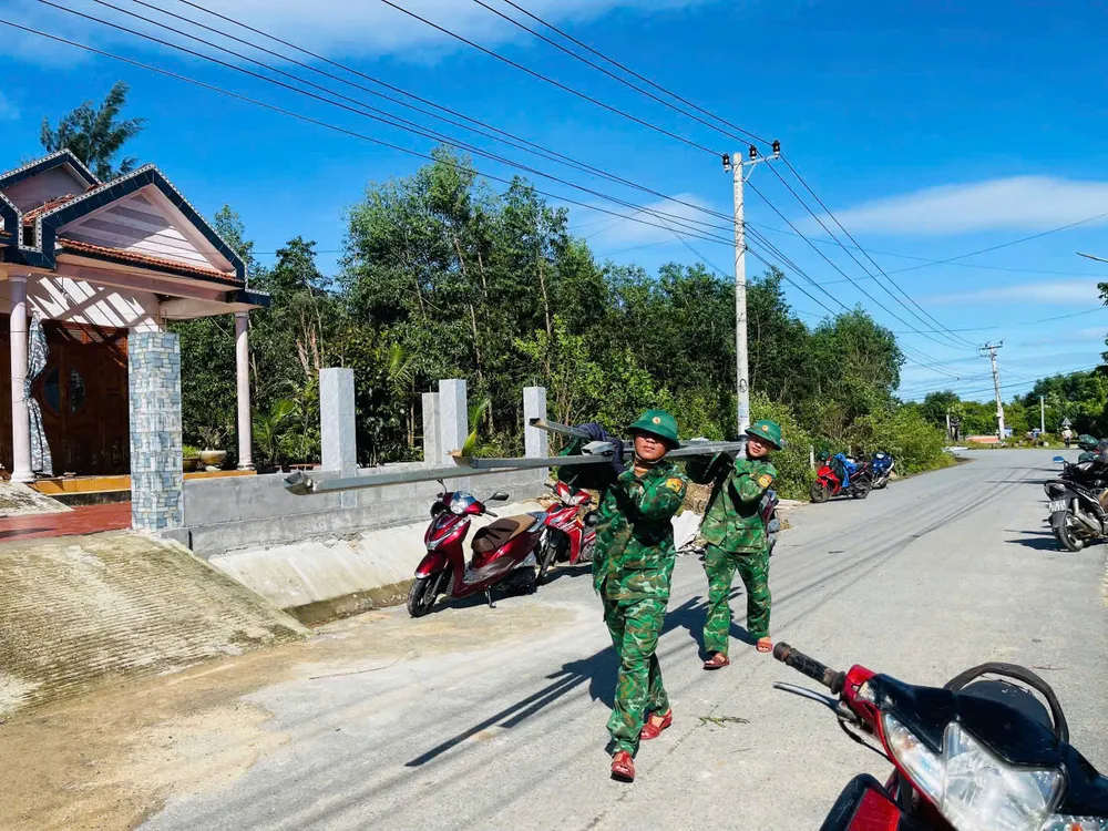 Soldaten van de Tam Thanh-grenswachtpost (grenswacht van de stad Da Nang) helpen de inwoners van de gemeente Tam Anh bij het verplaatsen van eigendommen die beschadigd zijn geraakt door storm nr. 13. 7-11-nha-toc-mai-1.jpg
