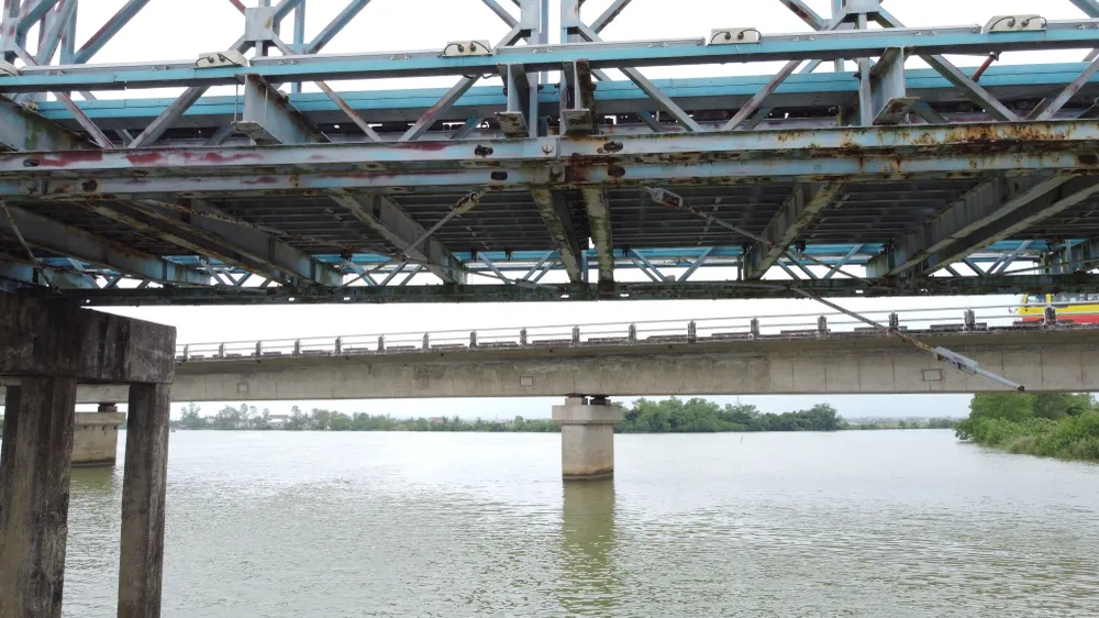Ở phía dưới cầu, một thanh sắt liên kết giữa dầm ngang và giàn chủ bị rơi xuống một bên Ở phía dưới cầu, một thanh sắt liên kết giữa dầm ngang và giàn chủ bị rơi xuống một bên