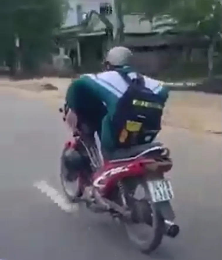 Em T. dùng chân lái xe máy. Ảnh: cắt từ video Em T. dùng chân lái xe máy. Ảnh: cắt từ video