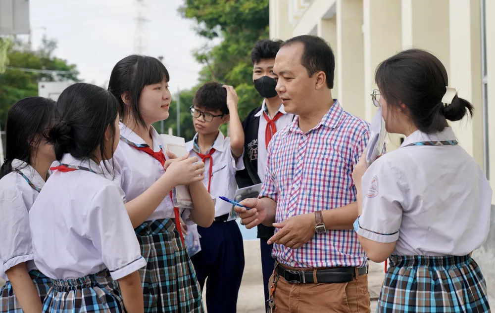 Thầy Dương Đức Phi, GV Tiếng Anh, hướng dẫn các em học sinh tại điểm thi Trường THCS Nguyễn Thị Hương, huyện Nhà Bè 9HH02774.jpeg