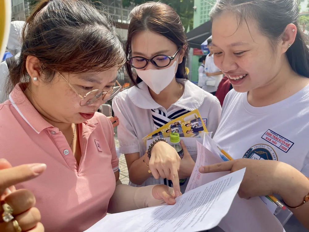 Giáo viên Trường THCS - THPT Quang Trung Nguyễn Huệ trao đổi, so đáp án sau khi hoàn thành môn Ngữ văn tại điểm thi Trường TH Thực hành Sài Gòn, quận 5. Ảnh: HOÀNG HÙNG IMG_0365.jpeg