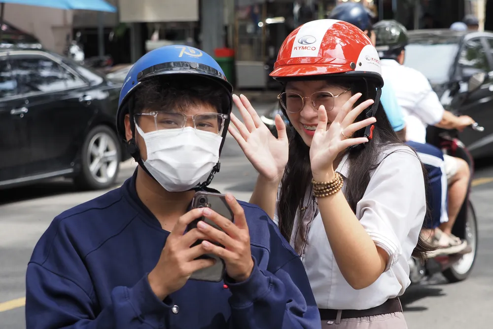Thí sinh rạng rỡ cùng phụ huynh sau khi hoàn thành môn Ngữ văn tại điểm thi Trường TH Thực hành Sài Gòn, quận 5. Ảnh: HOÀNG HÙNG IMG_0407.jpeg