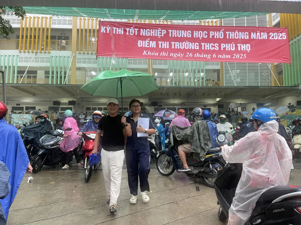 Niềm vui của thí sinh sau khi hoàn thành môn Toán, tại điểm thi Trường THCS Phú Thọ, quận 11, dưới cơn mưa lớn ngay sau giờ thi. Ảnh: HOÀNG HÙNG Niềm vui của thí sinh sau khi hoàn thành môn Toán, tại điểm thi Trường THCS Phú Thọ, quận 11, dưới cơn mưa lớn ngay sau giờ thi. Ảnh: HOÀNG HÙNG