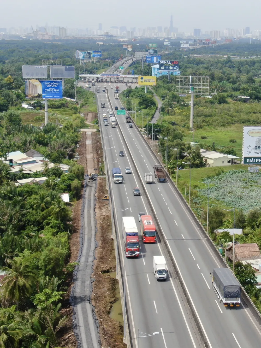 Mặt đường cao tốc hướng vào trung tâm TPHCM, phần mở rộng bên trái đang triển khai thi công đường công vụ. Ảnh: HOÀNG HÙNG IMG_2223.jpeg
