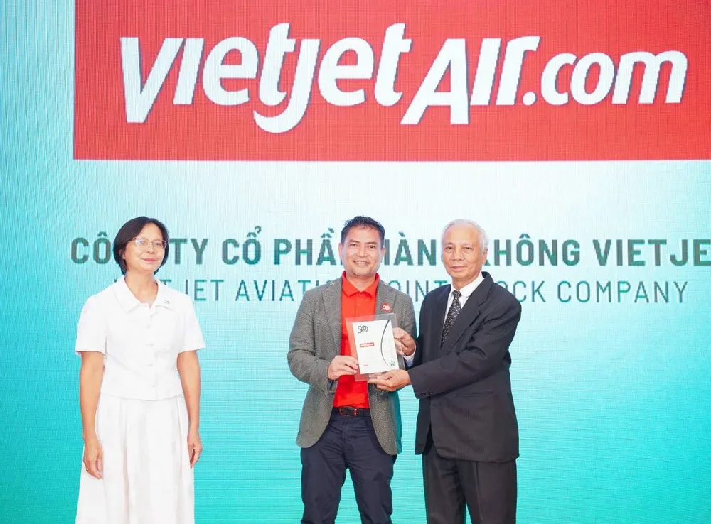 Ông Nguyễn An Di - Giám đốc Nhân sự Vietjet (đứng giữa) nhận giải thưởng tôn vinh Top 50 doanh nghiệp phát triển bền vững từ ban tổ chức z5695054293206_bf2de116e915e68f67ab58156747cae0.jpg