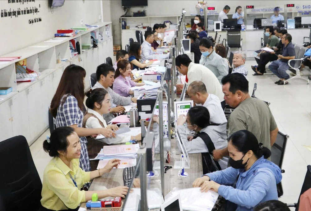 Người dân nộp hồ sơ thủ tục hành chính tại bộ phận một cửa UBND quận 12, TPHCM. Ảnh: SỸ BÌNH M4a.jpg