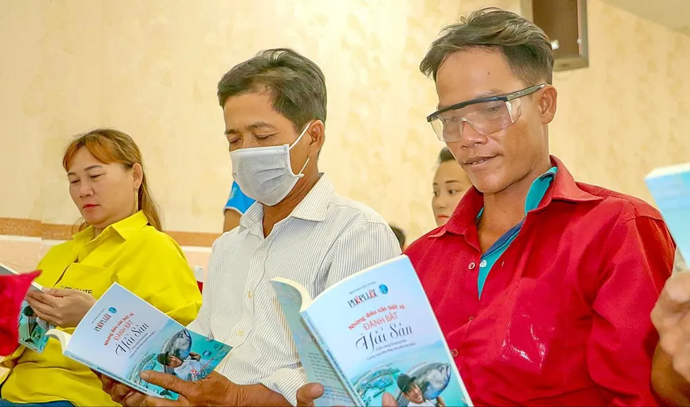 Ngư dân tìm hiểu thông tin qua cẩm nang Những điều cần biết về đánh bắt thủy hải sản $1g.jpg