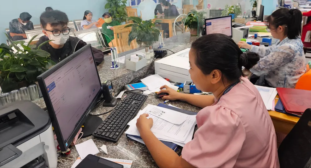 Công chức phường An Phú Đông, quận 12, TPHCM giải quyết hồ sơ thủ tục hành chính cho người dân. Ảnh: NGÔ BÌNH M4a.jpg