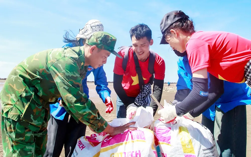 Jugendliche und Grenzschützer (Provinz Ninh Binh) räumen gemeinsam Müll an der Kim-Son-Mündung auf. Foto: XUAN HUYEN PSA Anh8-Daiduong (5).jpg