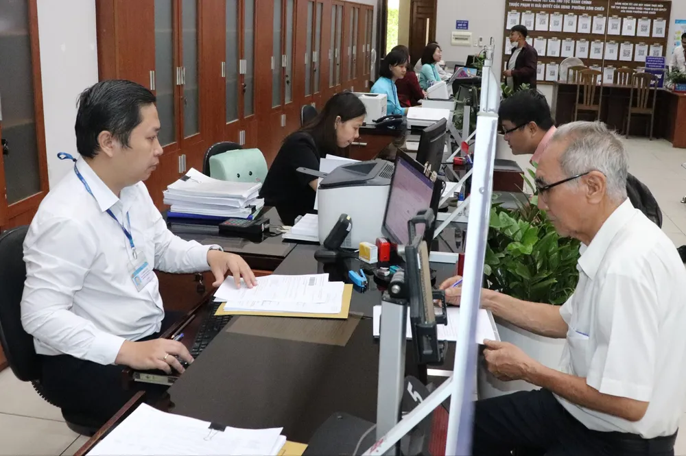 Cán bộ, công chức Bộ phận một cửa UBND quận 4 giải quyết hồ sơ cho người dân đến hết ngày 30-6. Ảnh: THÁI PHƯƠNG A3a.jpg