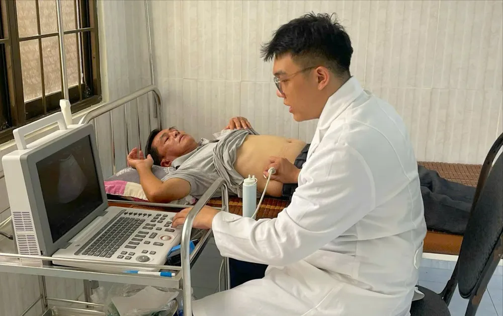 Thượng úy, bác sĩ quân y Bùi Nguyễn Thanh Nam khám, điều trị cho người bệnh tại Trung tâm Y tế quân dân y Côn Đảo. Ảnh: TRÚC GIANG O4b.jpg
