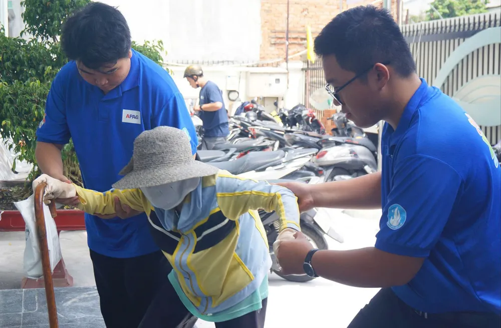 Sinh viên Phân hiệu Học viện Hành chính và Quản trị công TPHCM hỗ trợ người cao tuổi đến liên hệ công việc tại phường An Nhơn, TPHCM. Ảnh: THÁI PHƯƠNG Q3a.jpg