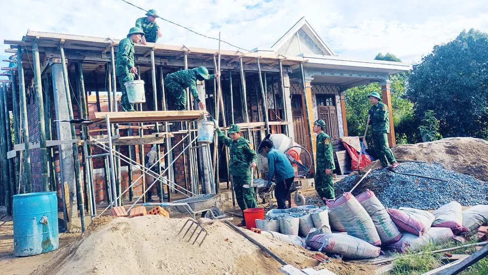 Cán bộ, chiến sĩ Đồn Biên phòng Quảng Nhâm (BĐBP TP Huế) xây dựng căn nhà mới giúp gia đình ông Hồ Văn Hinh ở thôn Căn Te, xã A Lưới 3, TP Huế. Ảnh: VĂN THẮNG N3b.jpg