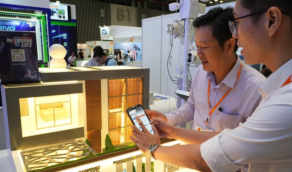 Các chuyên gia thử nghiệm cài đặt hệ thống điện thông minh bằng điện thoại tại Trung tâm triển lãm và hội nghị Sài Gòn (SECC), TPHCM. Ảnh: Hoàng Hùng $4b.jpg