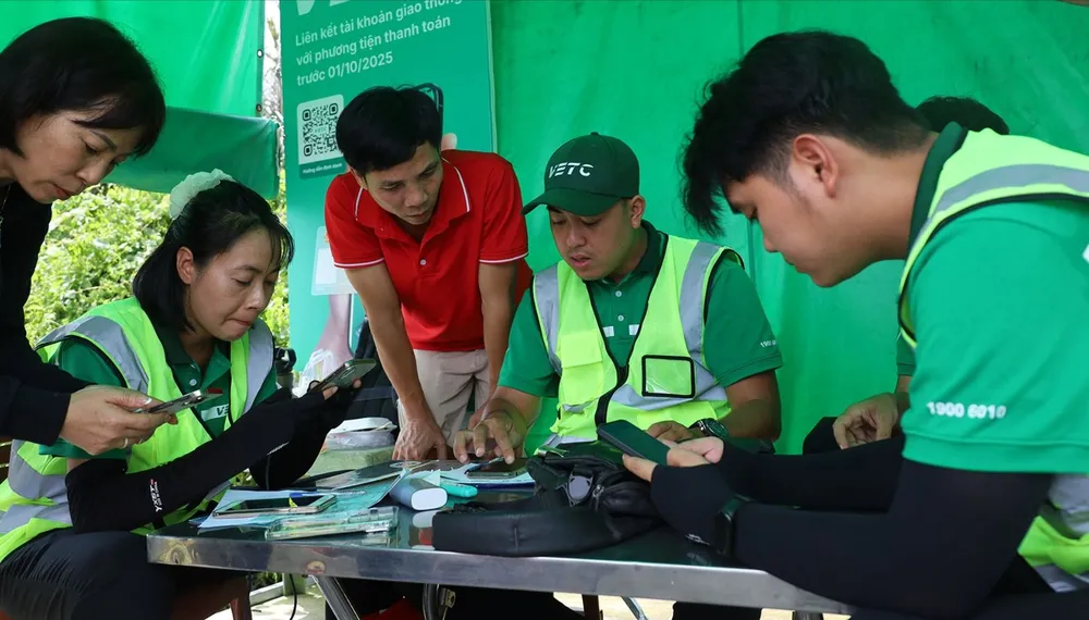Nhân viên VETC trạm thu phí Phước Long tuyến cao tốc TPHCM - Long Thành - Dầu Giây hướng dẫn tài xế chuyển đổi tài khoản giao thông. Ảnh: QUỐC HÙNG A5c.jpg