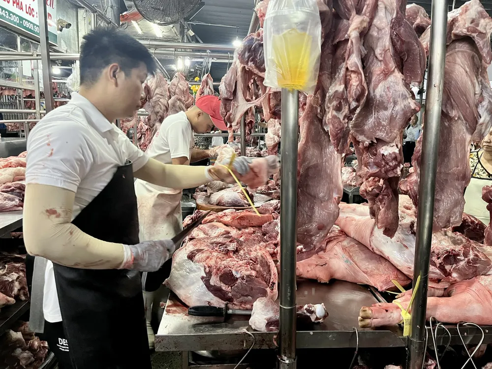 Tiểu thương bán thịt heo tại chợ đầu mối Hóc Môn. Ảnh: GIA HÂN W5A.jpg