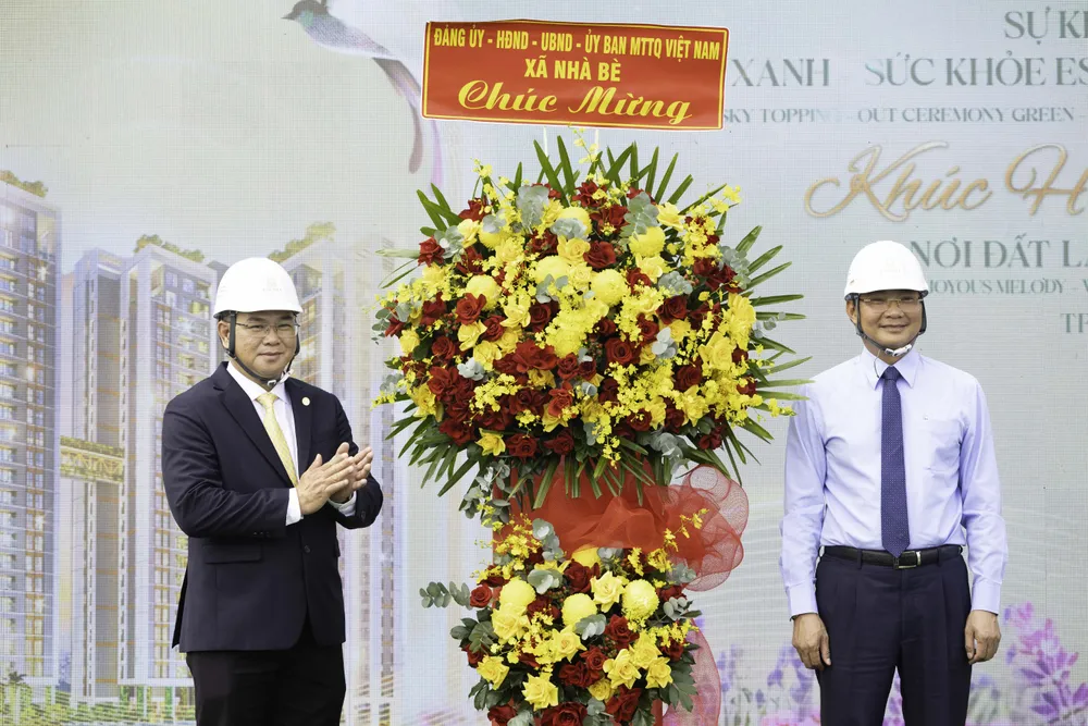 Ông Nguyễn Vũ Anh Tú - Tổng Giám đốc Công ty Phú Long (bên trái) nhận hoa chúc mừng từ ông Phan Ngọc Phúc - Bí thư Đảng uỷ xã Nhà Bè (bên phải). Ảnh Phú Long Hình 4.jpg