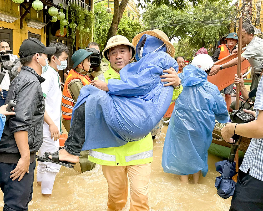Lực lượng Công an TP Đà Nẵng hỗ trợ đưa người dân từ vùng ngập lụt đến bệnh viện cấp cứu. Ảnh: NGUYỄN CƯỜNG %1d.jpg