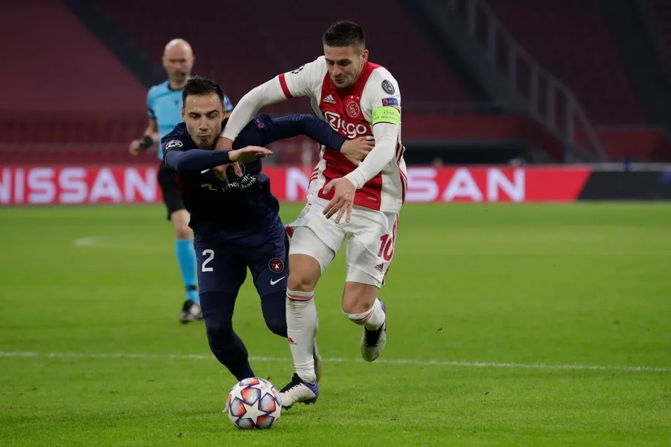 Johan Dion Cools trong pha tranh chấp với Hakim Ziyech tại Champions League