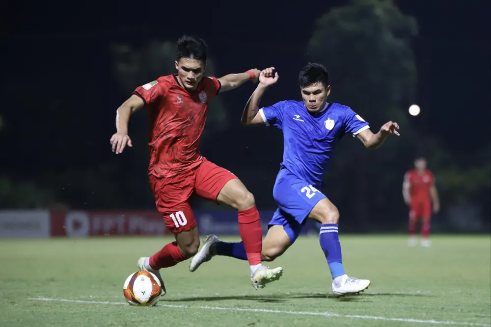 PVF CAND (áo đỏ) và Quảng Nam (áo xanh) bám nhau quyết liệt trong cuộc đua giành vé duy nhất thăng hạng V-League. ẢNH: MINH HOÀNG
