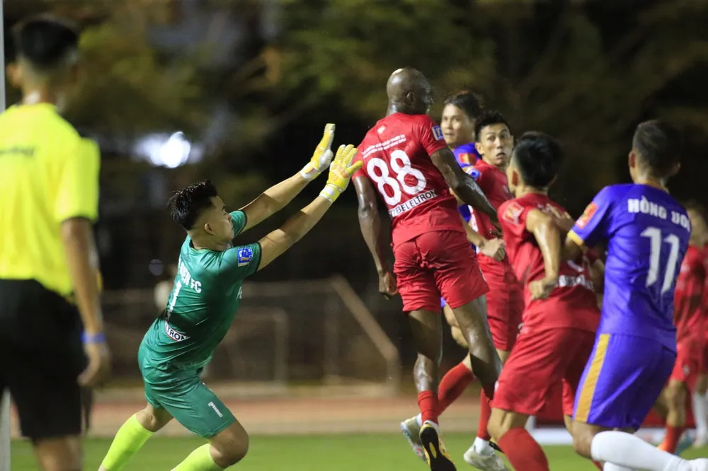 Cựu thủ môn U23 Việt Nam Phạm Văn Tiến và ngoại binh Epassi (áo đỏ). ẢNH: DŨNG PHƯƠNG