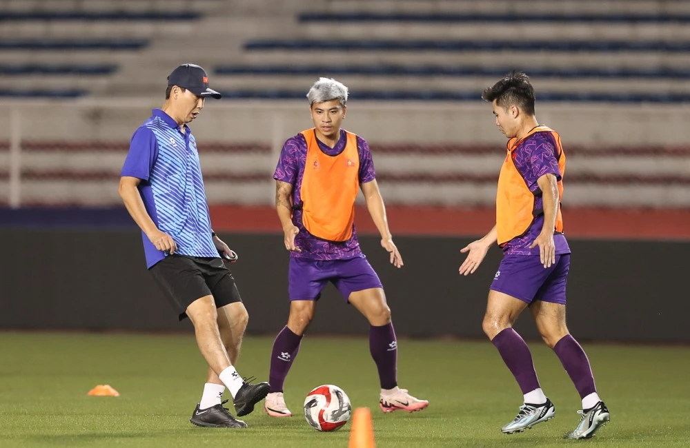 HLV Kim Sang-sik hướng dẫn các tuyển thủ Việt Nam chuyền bóng khi tập luyện trên sân nhân tạo Rizal Memorial. Ảnh: ĐOÀN NHẬT