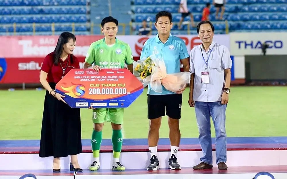 Trợ lý HLV Bùi Quang Huy cùng đội trưởng Trần Nguyên Mạnh của Nam Định buồn bã lên nhận bảng danh vị khi dự trận Siêu Cúp quốc gia 2024-2025. ẢNH: MINH HOÀNG 