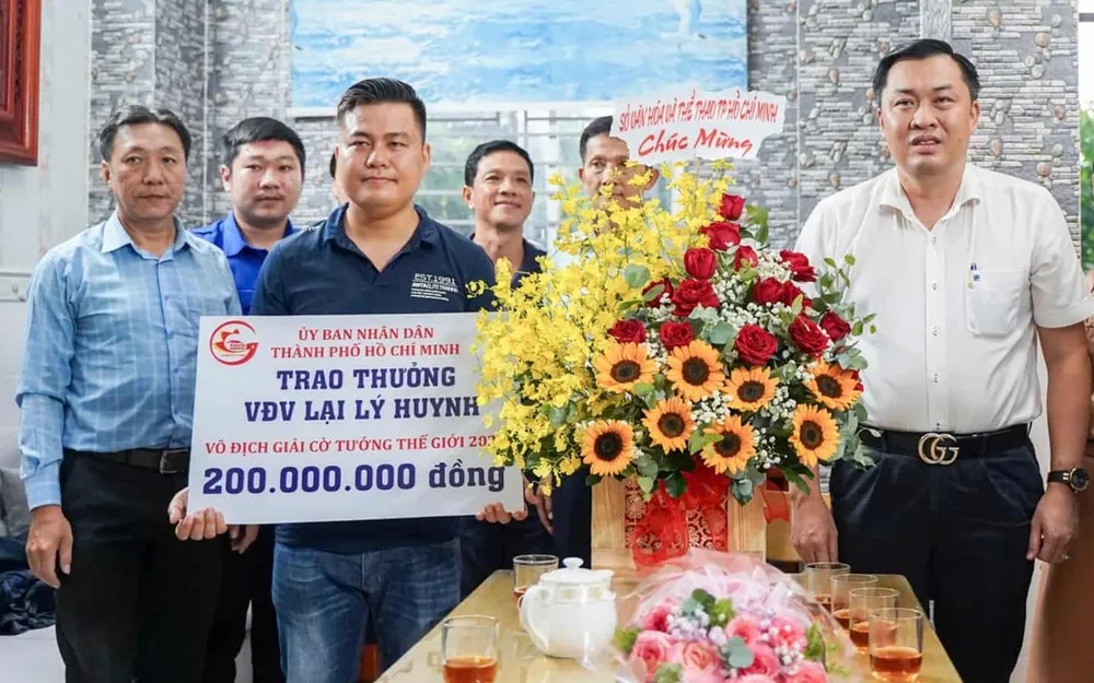 Ông Cao Văn Chóng, Phó Giám đốc Sở Văn hóa và Thể thao TPHCM, thừa ủy quyền Ủy ban Nhân dân TPHCM trao 200 triệu đồng tiền thưởng cho kỳ vương Lại Lý Huynh. ẢNH: TÂM HÀ 