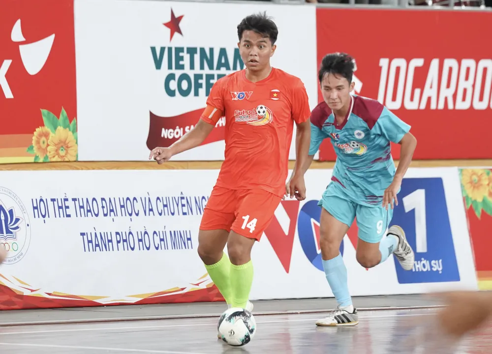 Trận đấu khai mạc giữa 2 đội futsal đến từ Trường Đại học Nông Lâm (áo cam) và Trường Đại học Ngoại ngữ - Tin học (áo xanh). ẢNH: TÂM HÀ