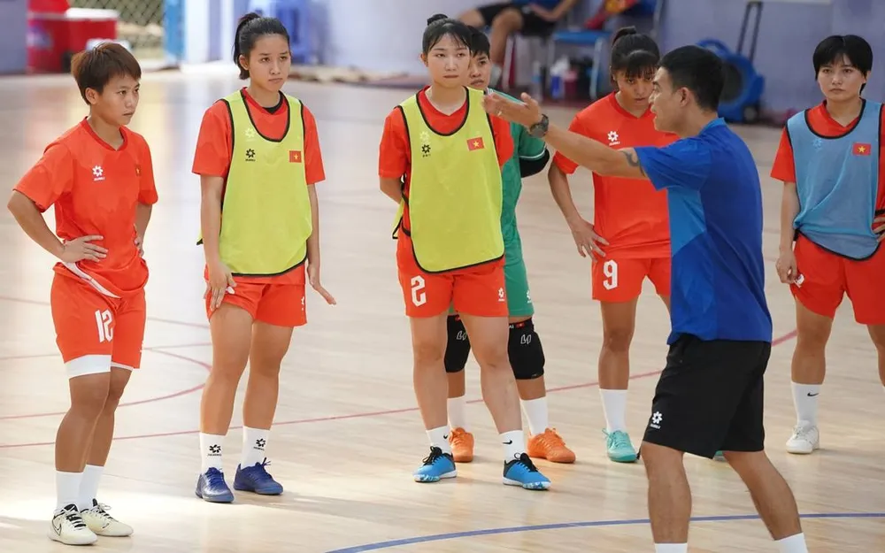 HLV Nguyễn Đình Hoàng cùng các nữ tuyển thủ futsal Việt Nam quyết tâm hướng đến tấm huy chương vàng SEA Games 33. ẢNH: QUỐC KHANH 