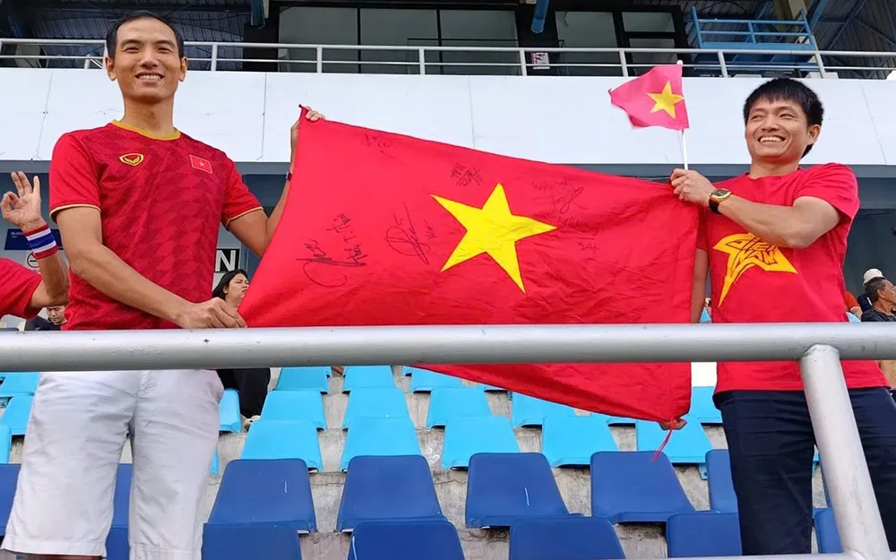 Anh Hoàng Quân (bên phải), đi từ Bangkok xuống Chonburi, để cổ vũ cho đội tuyển nữ Việt Nam thi đấu trận quyết định với Myanmar tại vòng bảng. ẢNH: HỮU THÀNH 