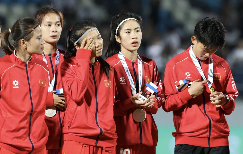 Thái Thị Thảo, Huỳnh Như, Nguyễn Thị Thanh Nhã và Trần Thị Hải Linh thẫn thờ ở bục nhận huy chương. ẢNH: DŨNG PHƯƠNG