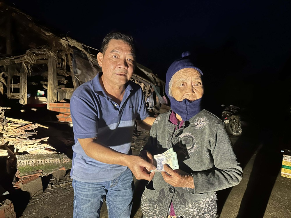 长虹旅游公司主理人温越强(左）捐助现金给当地贫困老人家。