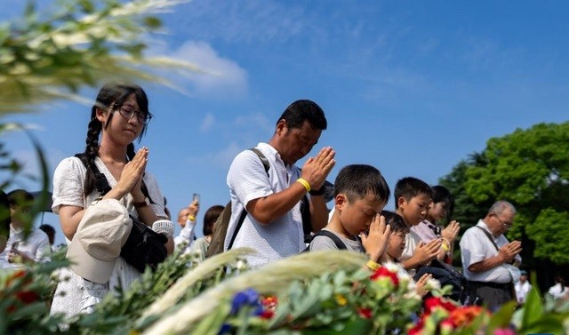 2024年8月6日，在日本广岛举行的遭原子弹轰炸79周年纪念仪式后，人们排队献花，纪念原子弹轰炸受害者 