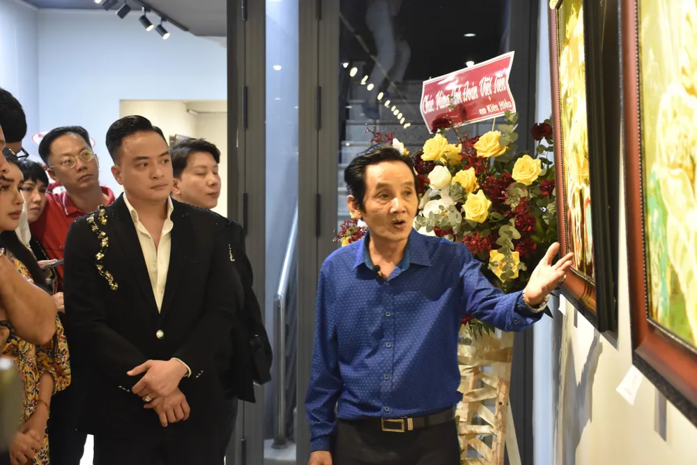 Hoạ sĩ Đoàn Việt Tiến giới thiệu tranh tại triển lãm cùng khách tham quan