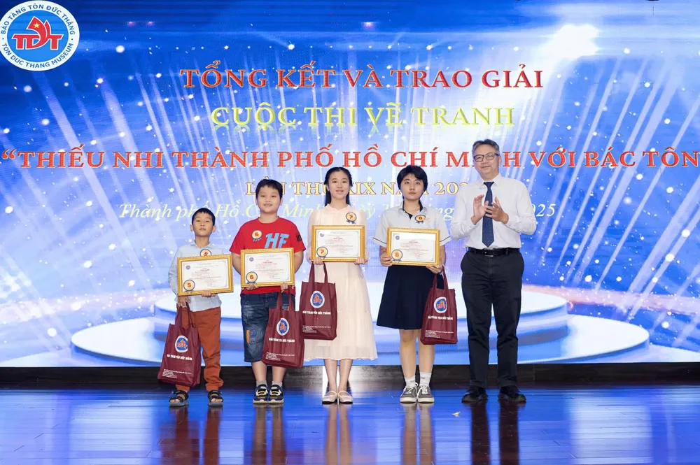 Ban tổ chức trao giải cho các em nhỏ Các bé đạt giải nhất cuộc thi.jpg