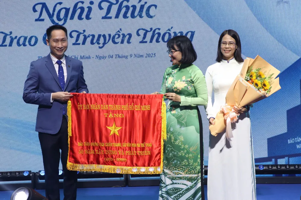 Phó Chủ tịch UBND TPHCM Trần Thị Diệu Thúy trao Cờ truyền thống của UBND thành phố cho đại diện Bảo tàng Chứng tích Chiến tranh. Ảnh: VĂN HÀ IMG_9494.JPG