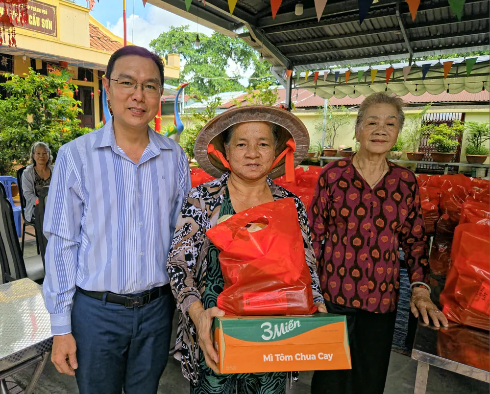 Cô Sáu Túy và ông Vũ Hữu Phú, Phó Chủ tịch Ủy ban Mặt trận Tổ quốc Việt Nam phường Bình Thạnh trao quà cho người dân Ông Hữu Phú và bà Sáu Túy trao quà cho người dân.jpg